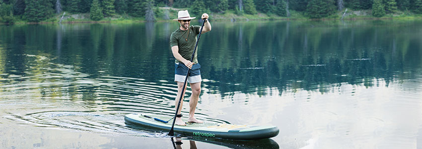 Guy on Retrospec Weekender iSUP paddling in lake