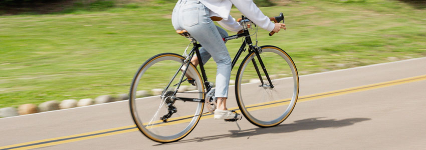 Girl riding black Retrospec Culver Road bike down road