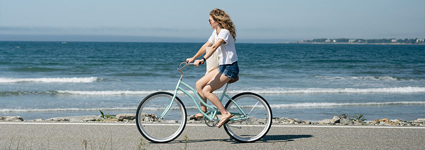 Girl riding Retrospec Chatham Beach Cruiser Bike along beach
