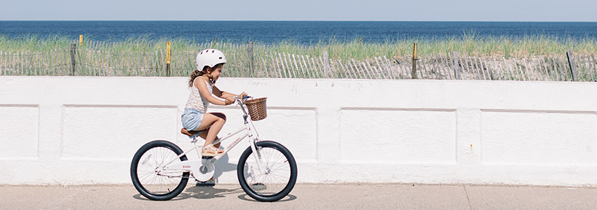 Child riding Retrospec Koda bike along beach path