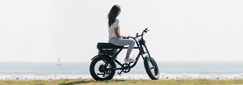 Girl sitting on black Retrospec Valen Rev electric bike