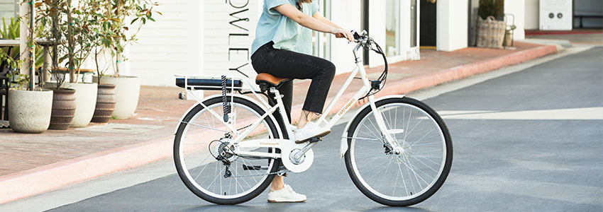 Girl on white Retrospec Beaumont Rev electric bike on quiet street
