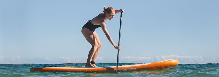 Girl paddling in water on Retrospec Weekender Inflatable Paddle Board