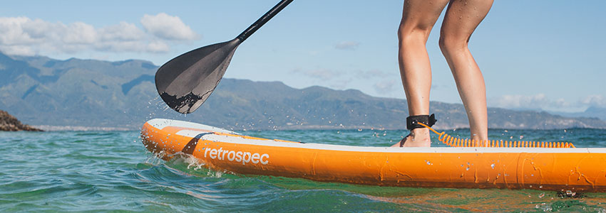 Girl paddling in water on Retrospec Weekender Inflatable Paddle Board