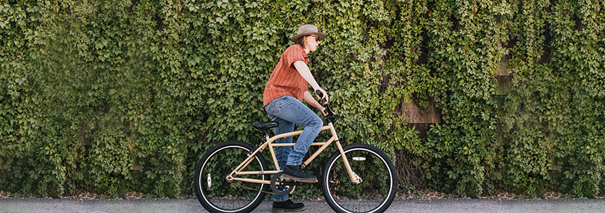 Girl riding Retrospec Sully Klunker Bike in front of vine wall