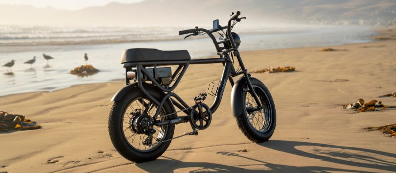 Matte black fat tire electric bike on sand at the beach