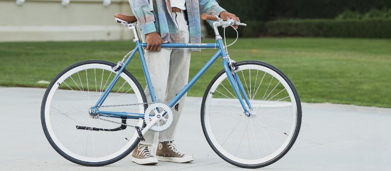 person holding a lightweight, blue commuter bike