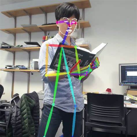 A person standing while holding a book, with an overlayed output of the inferred detections from a human pose (keypoint) model.
