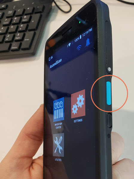 Photo of the scanner with the blue button on the left side circled